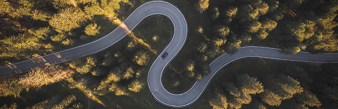 Aerial view of a curving road, representing markets navigating periods of volatility and change.